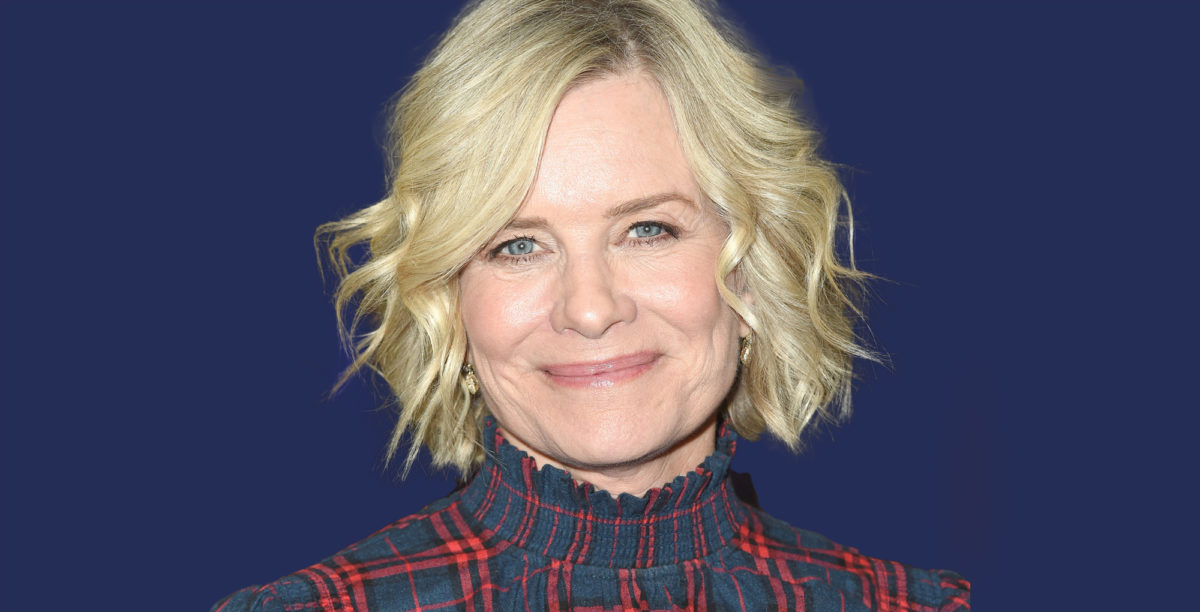mary beth evans of days of our lives against a blue background smiling