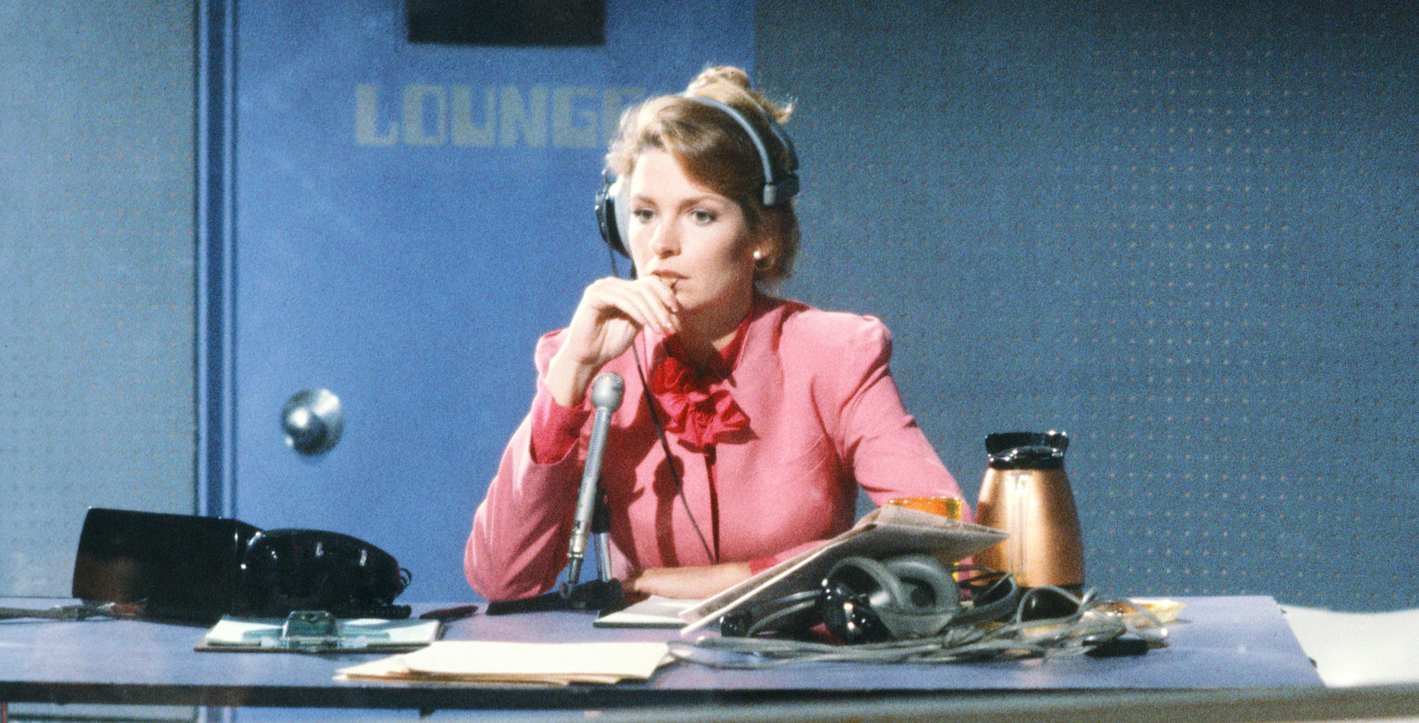 dr. marlena evans back in the early 80s working on her radio show wearing pink against a blue wall