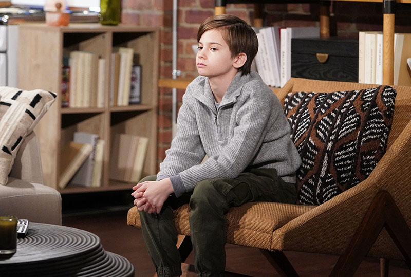 connor newman sits on a chair in his mom's apartment looking sad