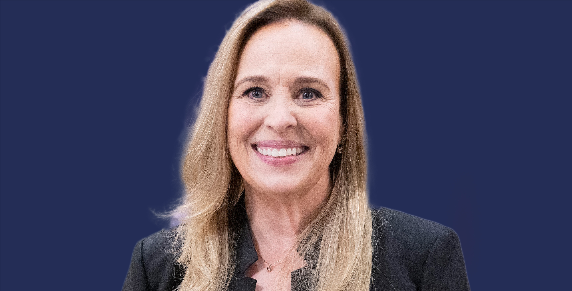 general hospital genie francis smiling on blue background wearing a black top