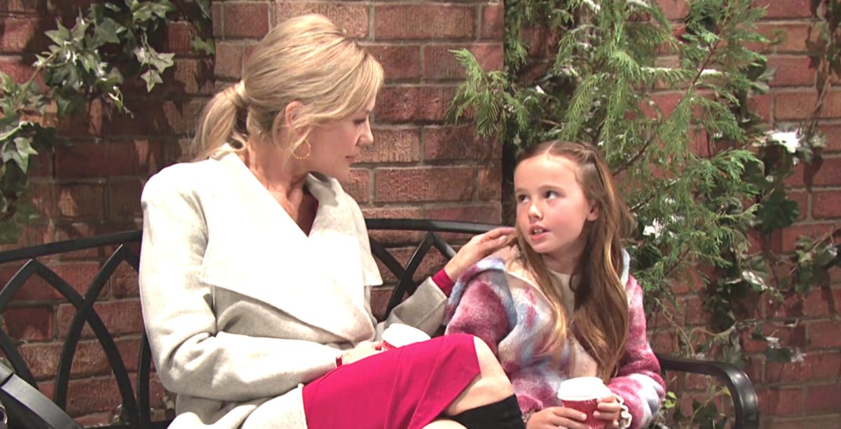 kristen diMera peers down at her daughter rachel as the two enjoy hot cocoa on a bench in the park