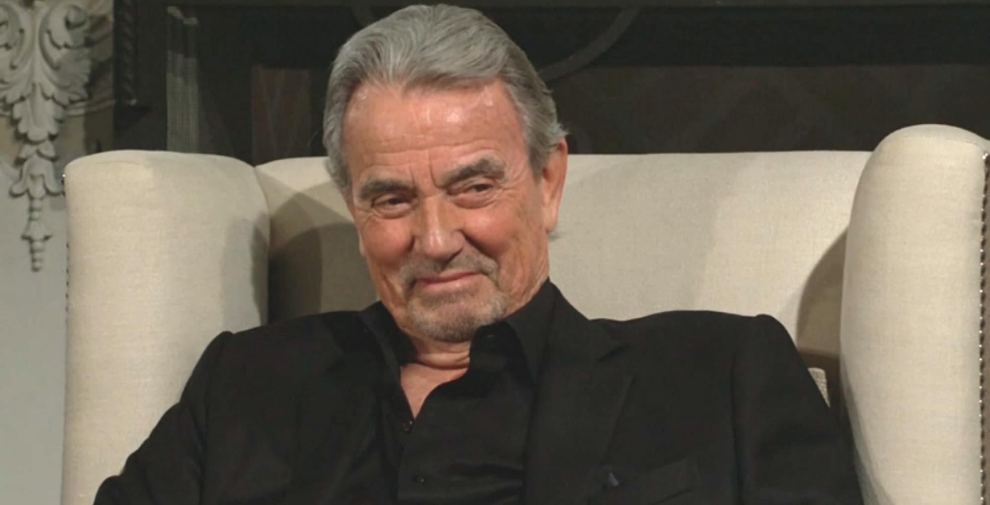 young and the restless spoilers victor newman in black smiling in a white chair