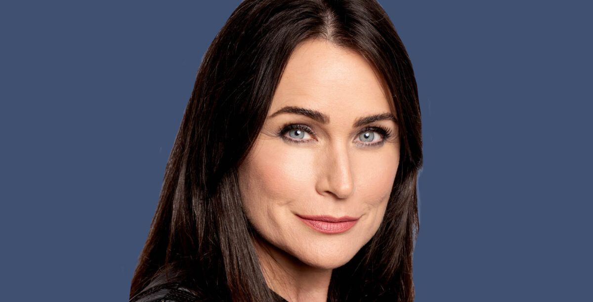general hospital and former bold and the beautiful star rena sofer smiles against blue background.