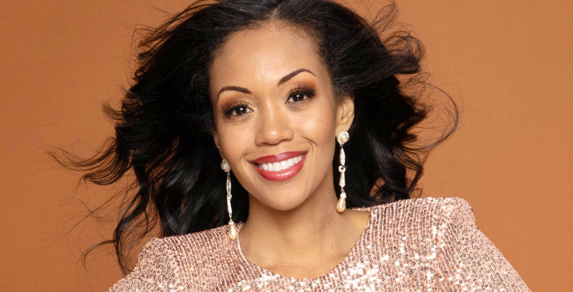 young and the restless mishael morgan smiling against gold background.