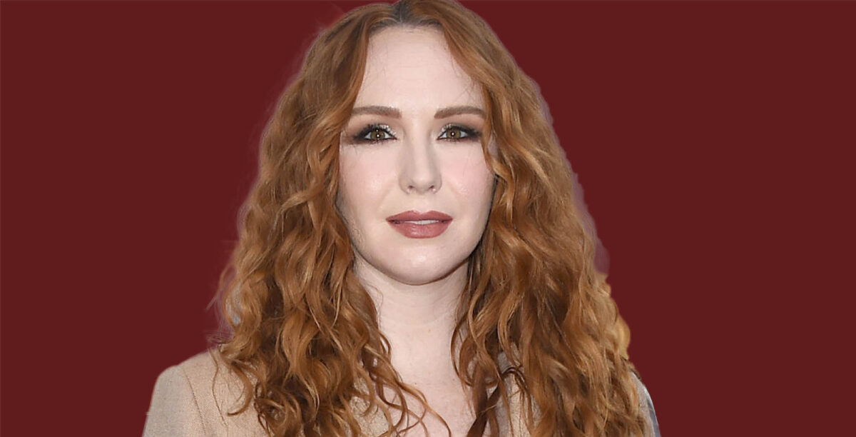 young and the restless star camryn grimes wearing tan on a burgundy background.