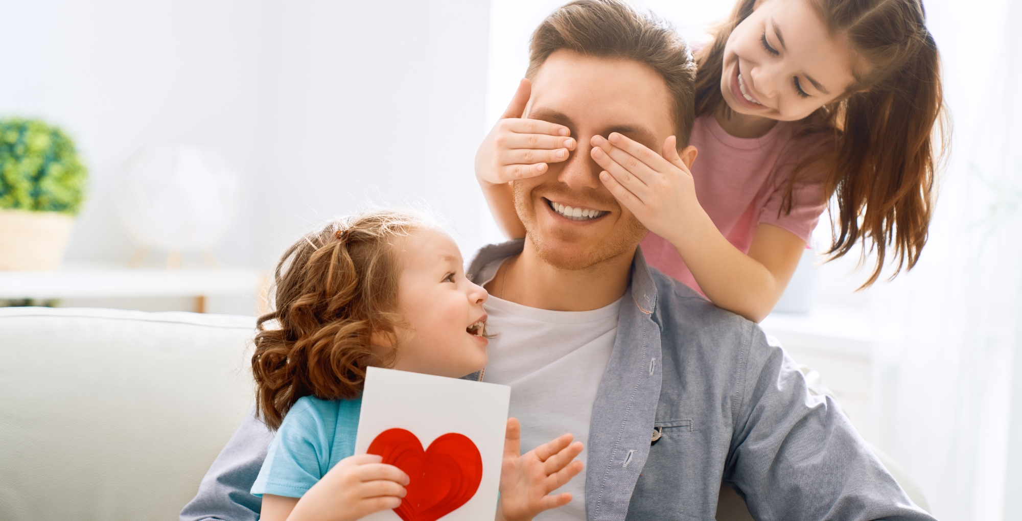 Father's Day gifts with a dad and two daughters holding a card.
